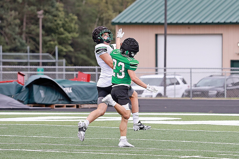 Evan Shoeder catches a pass over teammate Ben Olson (23) for a 50-yard touchdown during the Rhinelander High School football team’s Green vs. White intrasquad practice at Mike Webster Stadium Saturday, Aug. 10. The passing game stood out for the Hodags on Saturday as the team threw for 167 and four touchdowns during 11-on-11 sessions. (Bob Mainhardt for the River News)