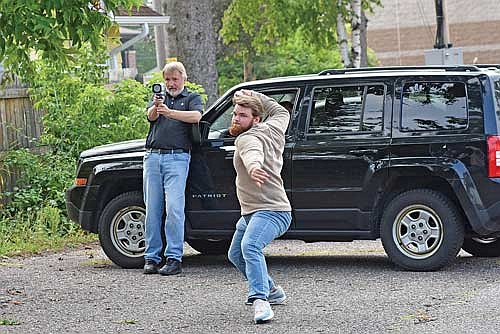 Mikey Rottier, right, goes through his throwing motion with Gregg Walker holding the radar gun Monday, Aug. 19 at The Lakeland Times in Minocqua. (Photo by Brett LaBore/Lakeland Times)