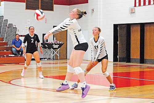 Cale Quade makes a pass with Greta Johnson (2) and Kieran Petrie (11) looking on against Medford Tuesday, Sept. 10 at Raider Hall in Medford. (Photo by Brett LaBore/Lakeland Times)