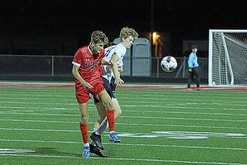 Brady Wolfe plays the ball against the defense of Medford’s Anthony Seidel in a 2-0 win Tuesday, Sept. 17 at Raider Field in Medford. (Photo by Matt Frey/Star News)