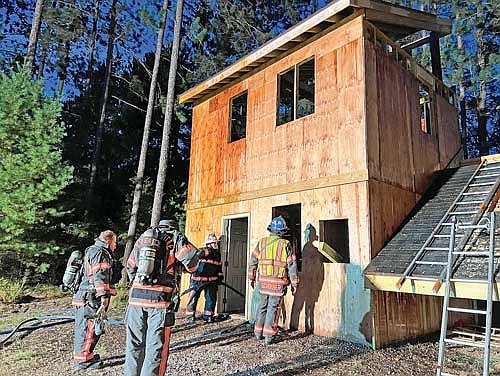 Arbor Vitae firefighters gather outside the new training tower before the start of a practical exercise. (Photo by Kate Reichl/Lakeland Times)