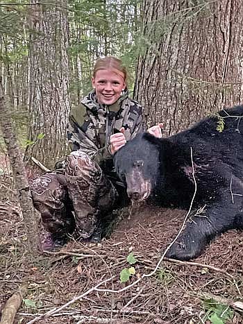 Tess Strasburg takes a picture with the black bear she harvested with her mom on Sunday, Sept. 22, in Minocqua. (Contributed photograph)