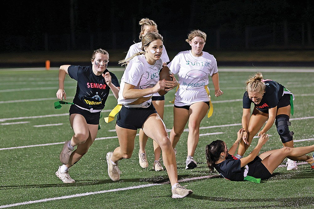 Junior Violet Biolo breaks a flag-pull attempt by senior Emma Deede and sprints down the sideline for a touchdown.