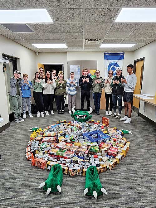 Members of the RHS FBLA/DECA club are preparing for their annual community service project, the Trick or Can food drive. Pictured are club members with the results of their efforts shortly after the 2023 can drive. (Submitted photo)