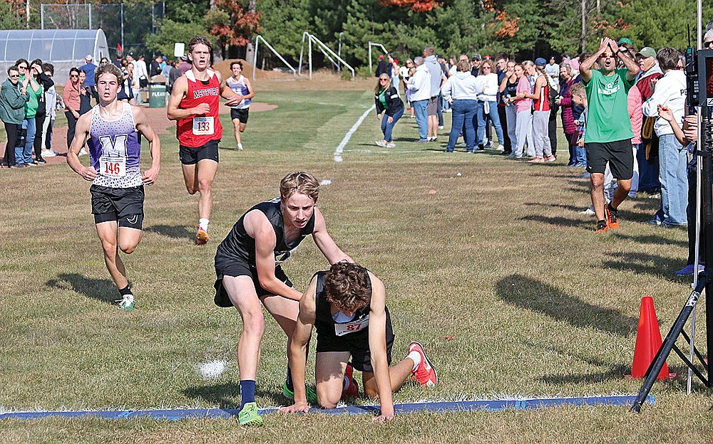 Rhinelander’s Grant Gremban attempts to aid teammate Brody Kowieski across the finish line of the GNC cross country meet in Eagle River Saturday, Oct. 19. Kowieski was running fourth with 400 meters to go before being overcome by exhaustion. Because Gremban aided Kowieski across the line, both runners were disqualified. (Bob Mainhardt for the River News)