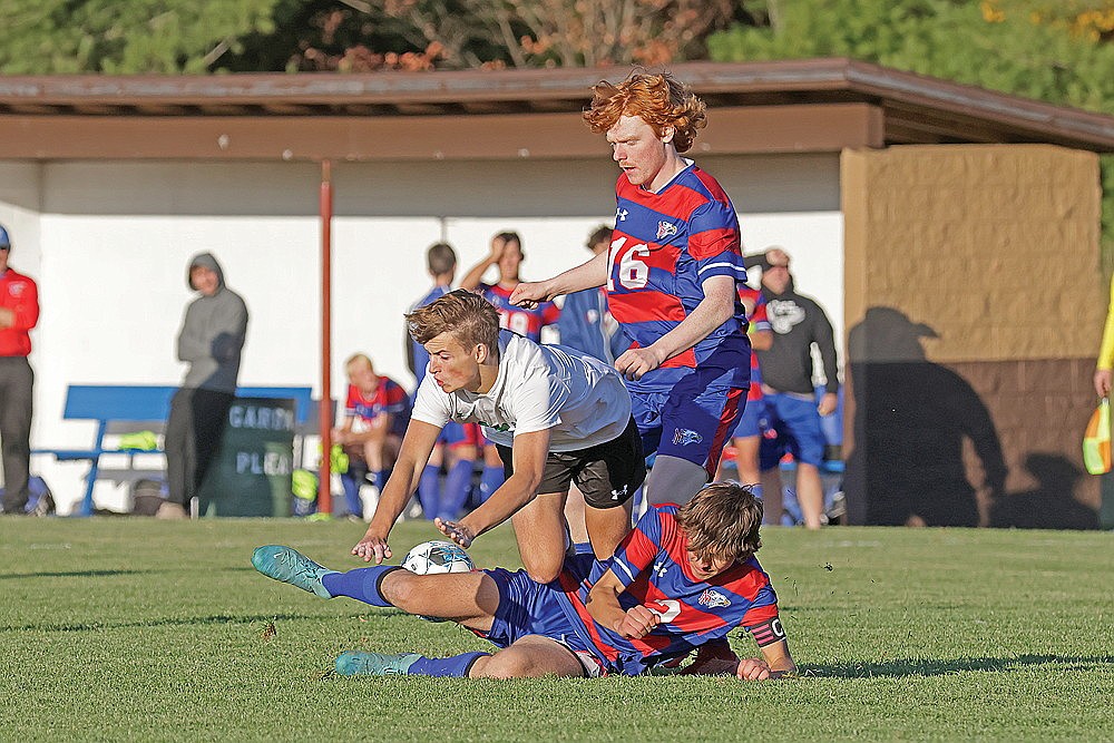 Rhinelander’s Charlie Johnson goes down between Northland Pines defenders Nick Boxrucker (2) and AJ Muench (16) during the second half of a GNC boys’ soccer game in Eagle River Thursday, Oct. 17. The Hodags lost to the Eagles 2-0 to finish fourth in the final GNC standings. (Jeremy Mayo/River News)