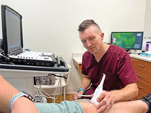 Dr. Benjamin Brusch, physical medicine and rehabilitation, demonstrates how he uses the ultrasound machine he indicated is top-of-the-line and helps make his job easier. (Photo by Trevor Greene/Lakeland Times)