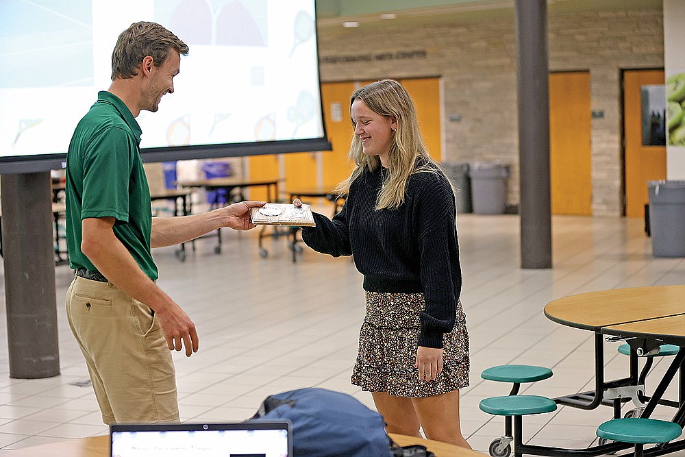 Kelsey Winter receives the Rhinelander High School girls’ tennis team’s most valuable player award from coach Matt Nichols during the team’s season-ending banquet at RHS commons Monday, Oct. 21. The award was voted on by members of the team. (Bob Mainhardt for the River News)