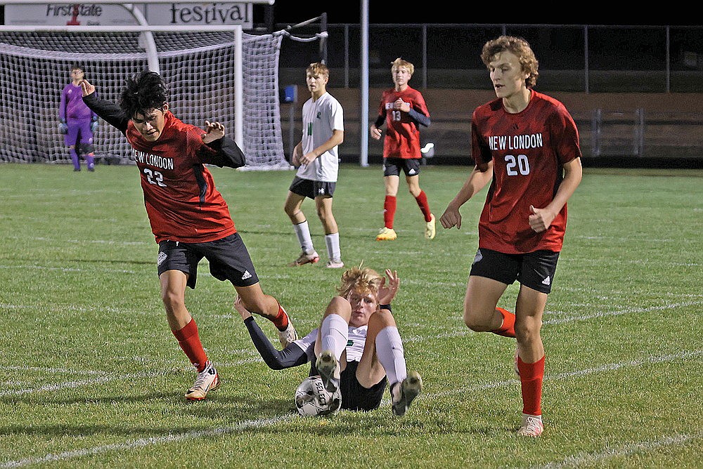 Rhinelander’s Aiden Ostermann falls while playing the ball against New London’s Oswin Menez (22) and Ryan Dalhoe (20) during the first half of a WIAA Division 3 boys’ soccer regional semifinal game in New London Thursday, Oct. 24. The Hodags lost to the Bulldogs, 4-1. (Bob Mainahrdt for the River News)