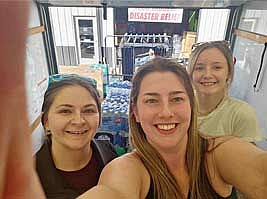 Kennedy Esposito, Kelly Kirst and Sarah Knowles take a quick photo while unloading a truck full of donations they transported to Asheville, North Carolina with the help of Knowles’ father, Kelly, on Oct. 20. The donations went towards those affected by Hurricane Helene in September and include many different items, ranging from fresh food and clothing to generators. (Contributed photograph)