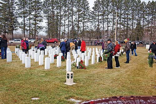 People lay wreaths at the graves of veterans buried in the Northwoods National Cemetery during Wreaths Across America Day on Saturday, Dec. 16, 2023. (Photo by Brian Jopek/Lakeland Times)