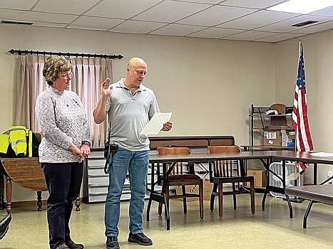 Daniel Metz reads the oath of office as he’s sworn in by Fifield town clerk Angie Richardson as Pike Lake Fire Department’s new chief during a town board meeting on Tuesday, Dec. 3, at the town hall in Fifield. (Photo by Trevor Greene/Lakeland Times)