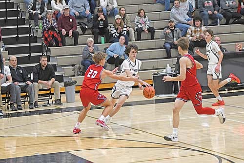 Benny Gahler dribbles the ball against the defense of Medford’s Peyton Ried in the second half of the Great Northern Conference opener Friday, Dec. 6 at Ted Voigt Court in Minocqua. (Photo by Brett LaBore/Lakeland Times)