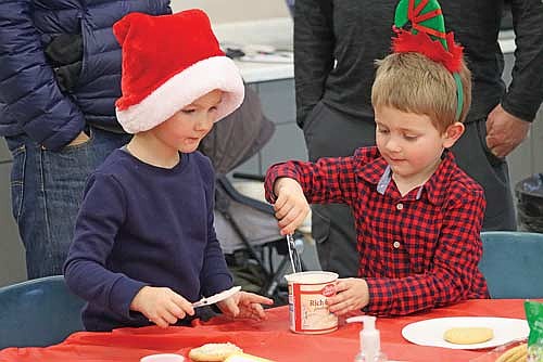 Minocqua Hazelhurst Lake Tomahawk School students Jacob Rasmussen, left, and Cael Clayton frost cookies during the school’s family day holiday party and mini concert on Thursday, Dec. 19, in Minocqua. (Photo by Kate Reichl/Lakeland Times)