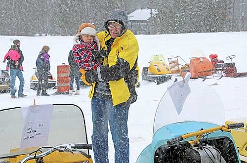 Wally Offenwanger shows his grandson Cooper McLamore all the vintage snowmobiles on display at the Cross Country Cruisers SnoFest fundraising event on Saturday, Jan. 13, 2024 in Arbor Vitae. (Photo by Trevor Greene/Lakeland Times)