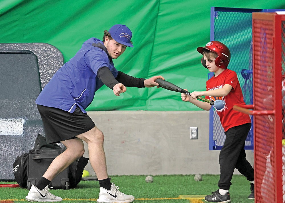 Isaac Bixby instructs a camper on how to lay a bunt down the third-base line.