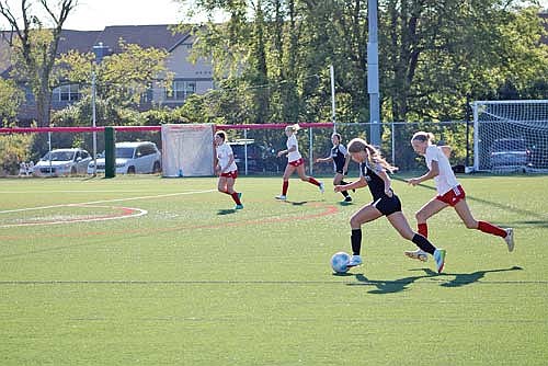 Malin Awker, left, dribbles the ball down the field in a MCU state game against Let Kids Fly (LKF) of Hartland during the Madison Tournament Sept. 7. (Contributed image)