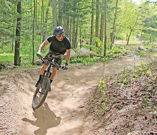 Nick Spatola winds around a corner while mountain biking at WinMan trails on Saturday, June 4, 2022, in Winchester. (Photo by Trevor Greene/Lakeland Times)