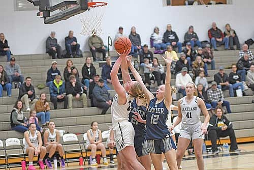 Cale Quade makes a basket with the foul against the defense of Xavier’s Ali Tylinski (21) and Makenna Brightman (12) in the second half of a 73-32 win Saturday, Jan. 25 at Ted Voigt Court in Minocqua. (Photo by Brett LaBore/Lakeland Times)