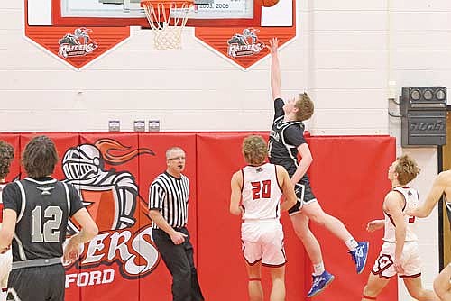 Jackson Burnett scores over Medford’s Peyton Ried in a conference game Friday, Jan. 24 at Raider Hall in Medford. (Photo by Matt Frey/Star News)