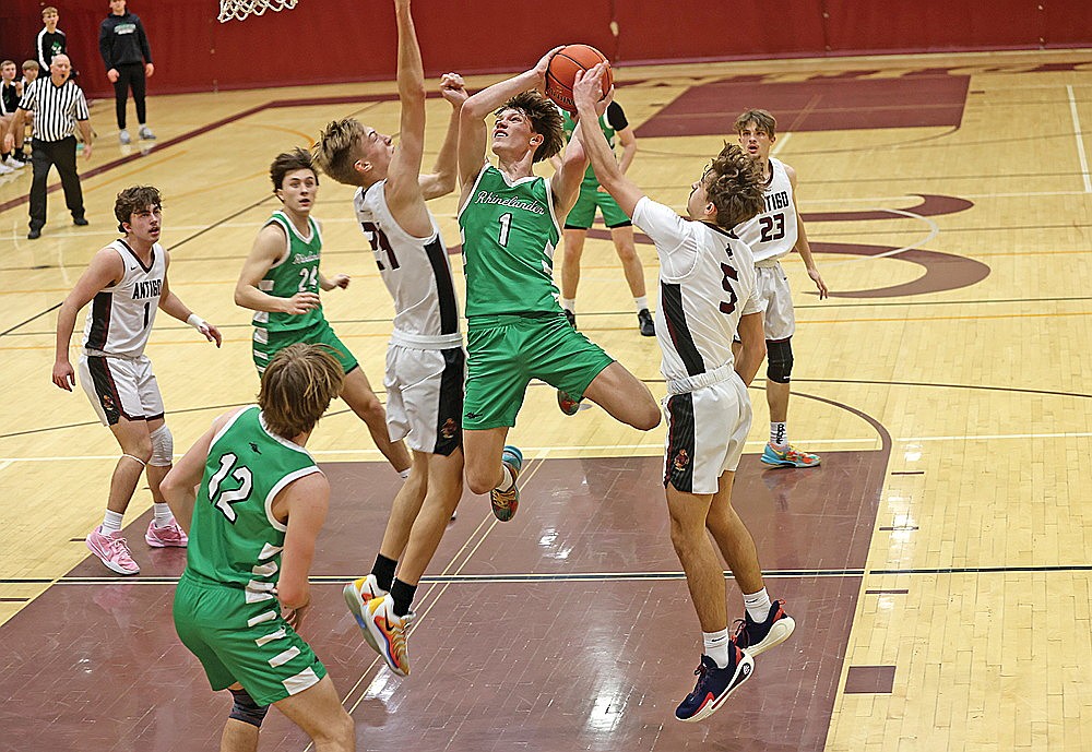 Rhinelander’s Jatyn Barkus attempts to put up a shot between Antigo’s Mitch Meyer (24) and Gus Schuessler (5) during the first half of a GNC boys’ basketball game in Antigo Friday, Jan. 24. The Hodags lost 70-62, falling out of first place in the conference standings. (Bob Mainhardt for the River News)