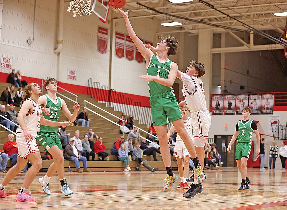 Rhinelander’s Jatyn Barkus drives past Wisconsin Rapids’ Isaiah Tork for a layup during the second half of a non-conference boys’ basketball game in Wisconsin Rapids Tuesday, Jan. 28. Barkus finished with a game-high 20 points as the Hodags defeated the Raiders, 63-45. (Bob Mainhardt for the River News)