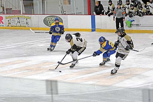 Aaron Wanta controls the puck at center ice with Kingsford’s Jake Crockford poke checking with Noah Dube, right, looking on in the third period Tuesday, Jan. 28 at Lakeland Hawks Ice Arena in Minocqua. (Photo by Brett LaBore/Lakeland Times)