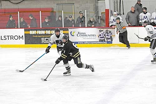 Lawson Bain controls the puck with Mosinee’s Jackson Lindell behind in the third period of a Great Northern Conference tournament semifinal game Tuesday, Feb. 11 at Mosinee City Recreation Center. (Photo by Brett LaBore/Lakeland Times)