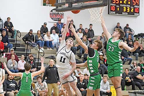 Jackson Burnett makes a shot off the glass against the contest of Rhinelander’s Rowan Wiczek (3) and Evan Shoeder (23) in the second half Friday, Feb. 14 at Ted Voigt Court in Minocqua. Burnett led Lakeland with 17 points. (Photo by Brett LaBore/Lakeland Times)