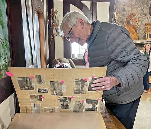 Wisconsin Gov. Tony Evers looks through a scrapbook full of historical information about and photographs of Camp American Legion in the camp’s main lodge on Monday, March 17. (Photo by Brian Jopek/Lakeland Times)