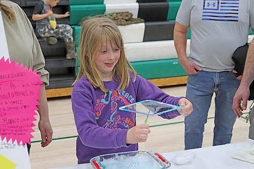 Second-grader Josie Foley demonstrates how surface tension can allow a hole to be created in a bubble during the elementary school Science Fair on Thursday, April 10, at Rhinelander High School. (Photo by Michael Strasburg/Lakeland Times)