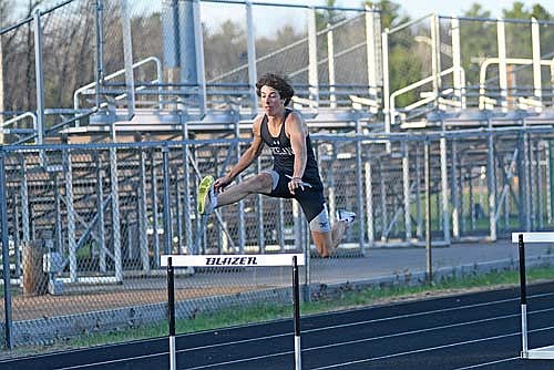 Owen Johnson goes over the hurdle in the 300-meter hurdles during the Lakeland Outdoor Invite Tuesday, May 6 at IncredibleBank Field in Minocqua. Johnson finished second with a time of 46.78, his first time running the event. (Photo by Brett LaBore/Lakeland Times)