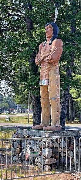 The Chief St. Germain statue in front of the St. Germain chamber of commerce office in the summer of 2023 after chamber personnel installed a fence around it. (Photo by Brian Jopek/Lakeland Times)