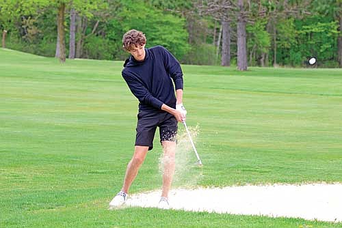 Jeremy Hensen chips the ball off the edge of the sand trap at the fifth hole of the seventh leg of the Great Northern Conference Tournament Monday, May 19 at Black River Golf Course in Medford. Hensen was named the conference’s Player of the Year. (Photo by Matt Frey/Star News)