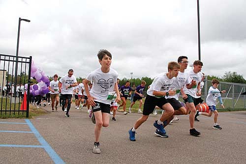 The field led by, from left to right, Wyatt Crowell, Michael Brunette, Asher Rivord, Cyrus Leisure and Lucas Rossing, takes off from the starting line to begin the 5K race. (Photo by Jeremy Mayo/River News)