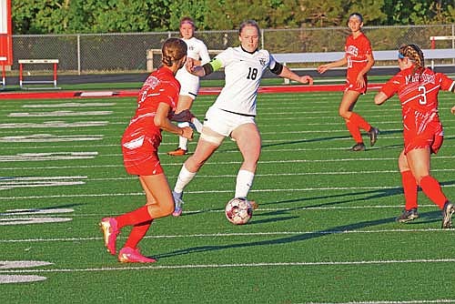 Cale Quade advances the ball between Medford’s Greta Seidel, left, and Talyn Peterson in the first half of a 1-0 win Thursday, May 22 at Raider Field in Medford. Quade scored the game-winning goal in the 76th minute. (Photo by Matt Frey/Star News)