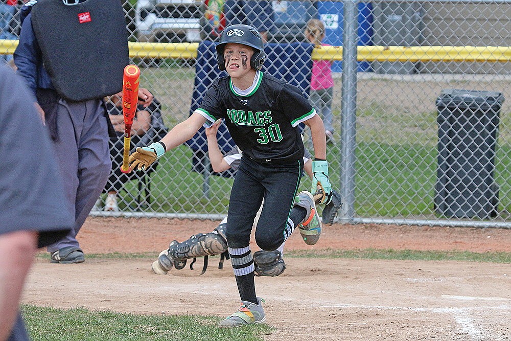 Rylan Pasanen, sporting Dan Bauer’s initials on his face, tosses his bat after drawing a walk during an 11U game at Hodag Park Sunday, May 25.