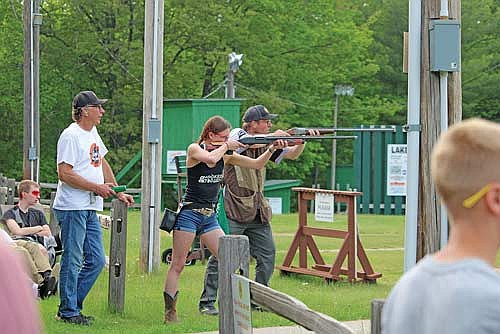 Coach Noel Schultz watches as varsity shoother Amelia Wigant beats out head coach Tom Oestreich in the team’s annual Annie Oakley shoot to win a free round of shooting at the Harshaw Sportsman’s Club on Monday, June 2, in Minocqua. (Photo by Trevor Greene/Lakeland Times)