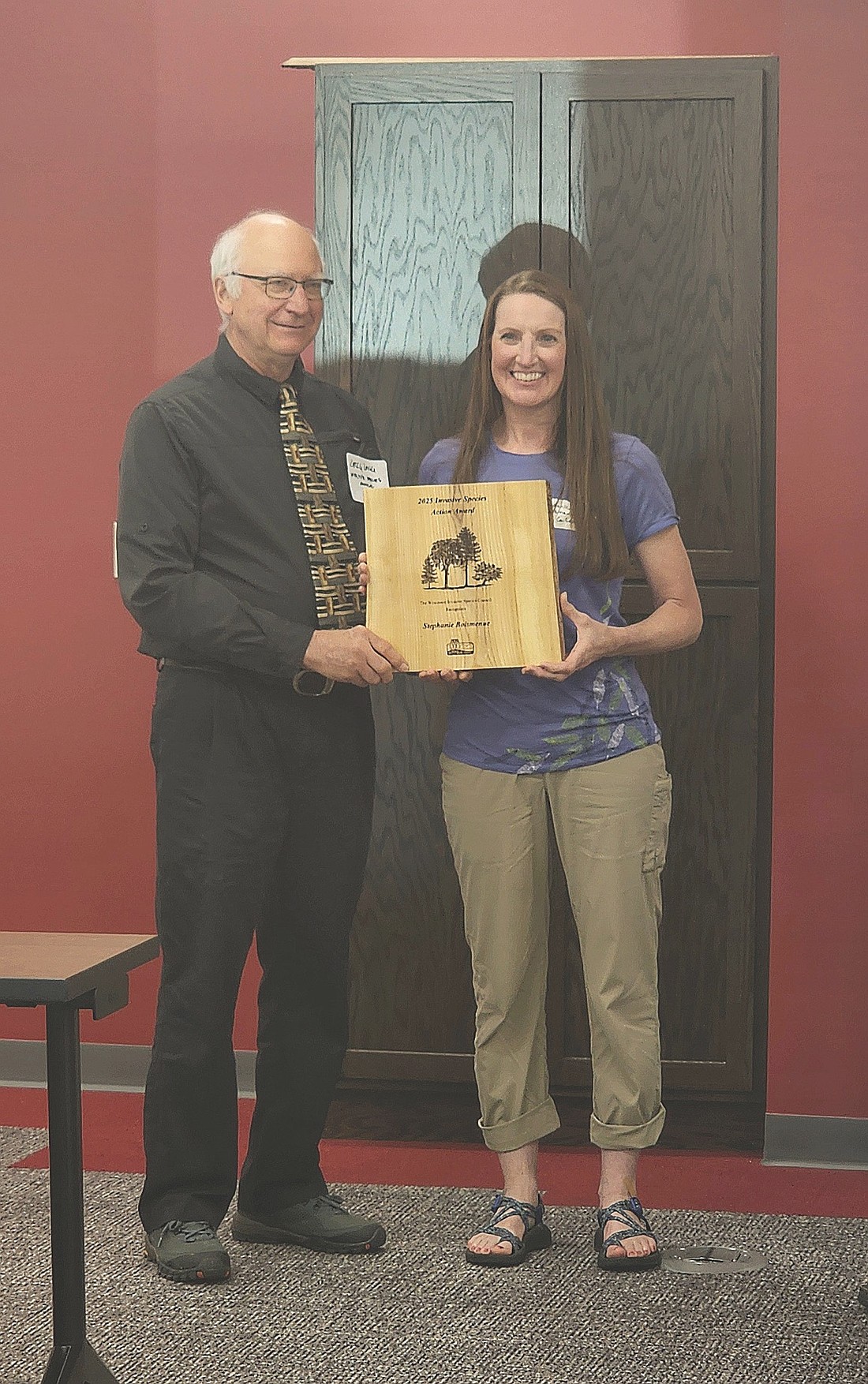 Tom Bueschel, Wisconsin Invasive Species Council chair, presents an award to Stephanie Boismenue, AIS coordinator for Oneida County. (Contributed photograph)