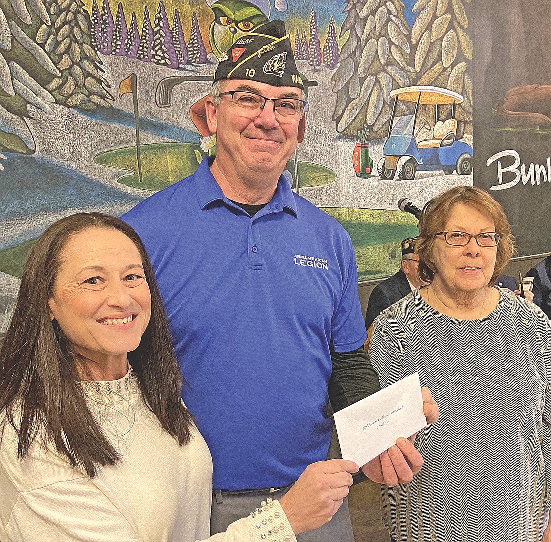 Carla Ruuskanen, left, and Sandra Edington, right, accept a check on behalf of the Northwoods Veterans Homestead in Rhinelander from Wausau  American Legion post commander Tony Nardi. (Contributed photograph)