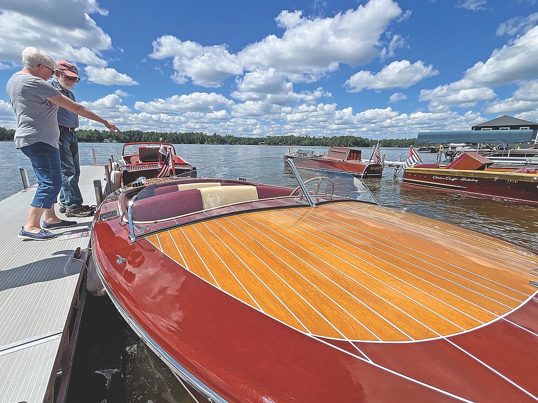 Alene Lantz points out a detail of a 1947 Century SeaMaid to her husband Paul during the 2024 Minocqua Boat Show at Torpy Park. (Photo by Trevor Greene/Lakeland Times)