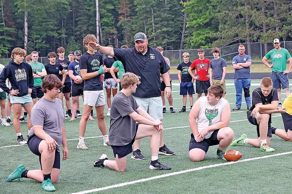 Rhinelander High School football coach Aaron Kraemer instructs offensive linemen, from left to right, Parker McCone, Gage Anderson, Landon Webster and Leander Sprecksel, during a summer contact day at Mike Webster Stadium Wednesday, June 11. The three-hour camp marked the team’s first organized activity of the summer. (Bob Mainhardt for the River News)