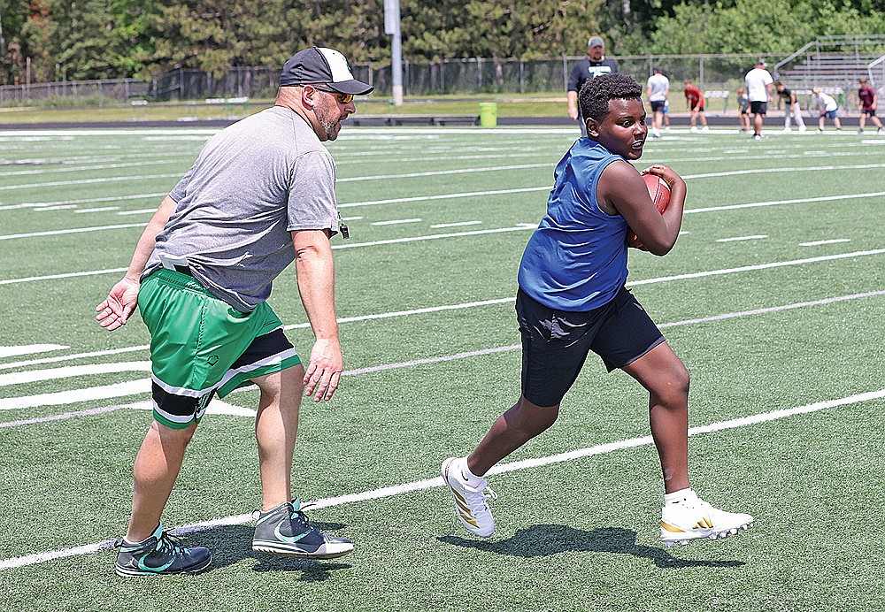 Jaxon Eades takes a handoff during camp Monday, June 23.