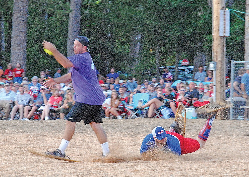 Gunner Dunbar of the Lake Tomahawk Snowhawks eats some sawdust as he dives for second base while Mikey Maize of the Chicago All-Stars works to gather in the baseball during the 2025 edition of Fourth of July Lake Tomahawk Snowshoe Baseball. (Brian Jopek/Lakeland Times)
