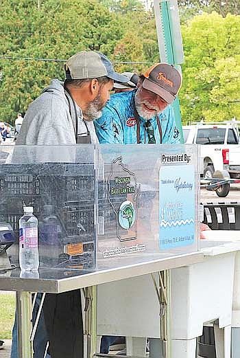 Chet Netzel (left) and Gregg Kizewski get ready to weigh in anglers catches at the 2024 Rod Gaskill Memorial Bass Tournament. (Photo by Beckie Gaskill/Lakeland Times)