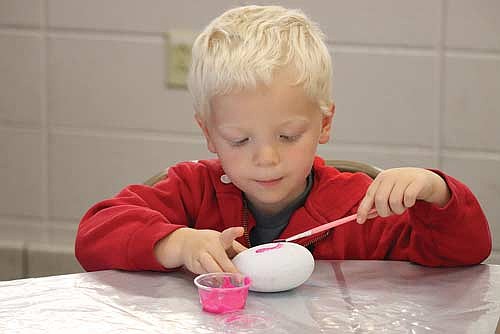 Three-year-old Henry Hoban enjoys free rock painting at the 56th Annual Gem and Mineral Show on Friday, July 18, at Lakeland Union High School in Minocqua. (Photo by Kate Reichl/Lakeland Times)