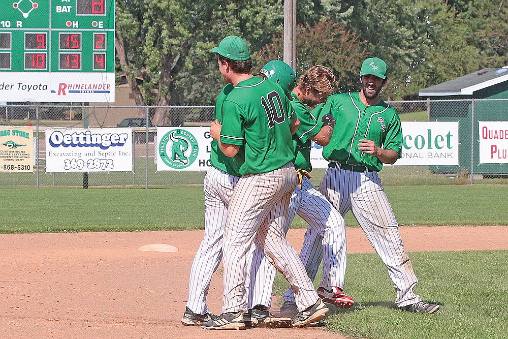 Rhinelander’s Sam Schneider (10), Quinn Lamers (second from right) and Martin Hoger (far right) congratulate Owen Kurtz after Kurtz hit a walk-off double in the bottom of the ninth inning to defeat the Whittlesey Reds in a Dairyland League baseball game at Stafford Field Sunday, July 27. The River Monsters scored four times in the ninth to defeat the Reds, 10-9. (Bob Mainhardt for the River News)