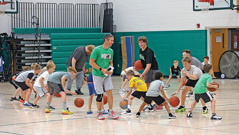Rhinelander High School boys’ basketball coach Derek Lemmens instructs players during a ball-handling drill as part of Hodag Hoops Camp at the Jim Miazga Community Gymnasium Monday, July 28. The four-day camp for players entering kindergarten to ninth grade concluded Thursday. (Bob Mainhardt for the River News)