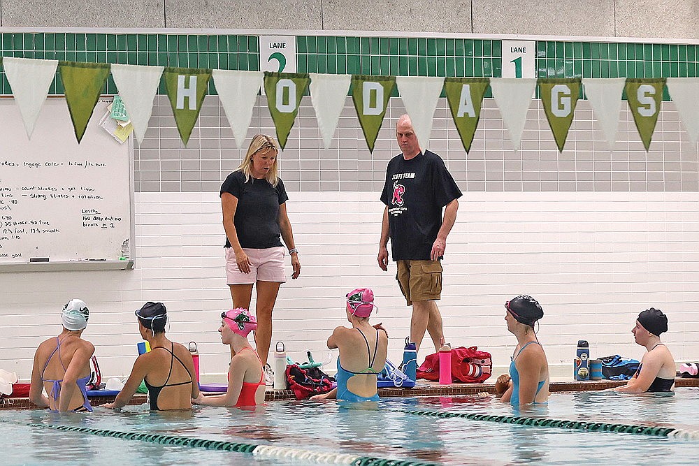 Rhinelander High School girls’ swim coach Jenny Heck and assistant Brent Olson address members of the team during practice Tuesday, Aug. 12 at the Heck Family Community Pool. (Bob Mainhardt for the River News)