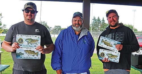 Brendan Garrigan (left) and Kyle Martinson (right), with tournament weigh-master Chet Netzel, took top spot in the 7th Annual Rod Gaskill Memorial Bass Tournament on Boom Lake with 17.45 pounds. The pair also took big Smallmouth with a 4.74 pound river bronzeback. (Photo by Beckie Gaskill/Lakeland Times)